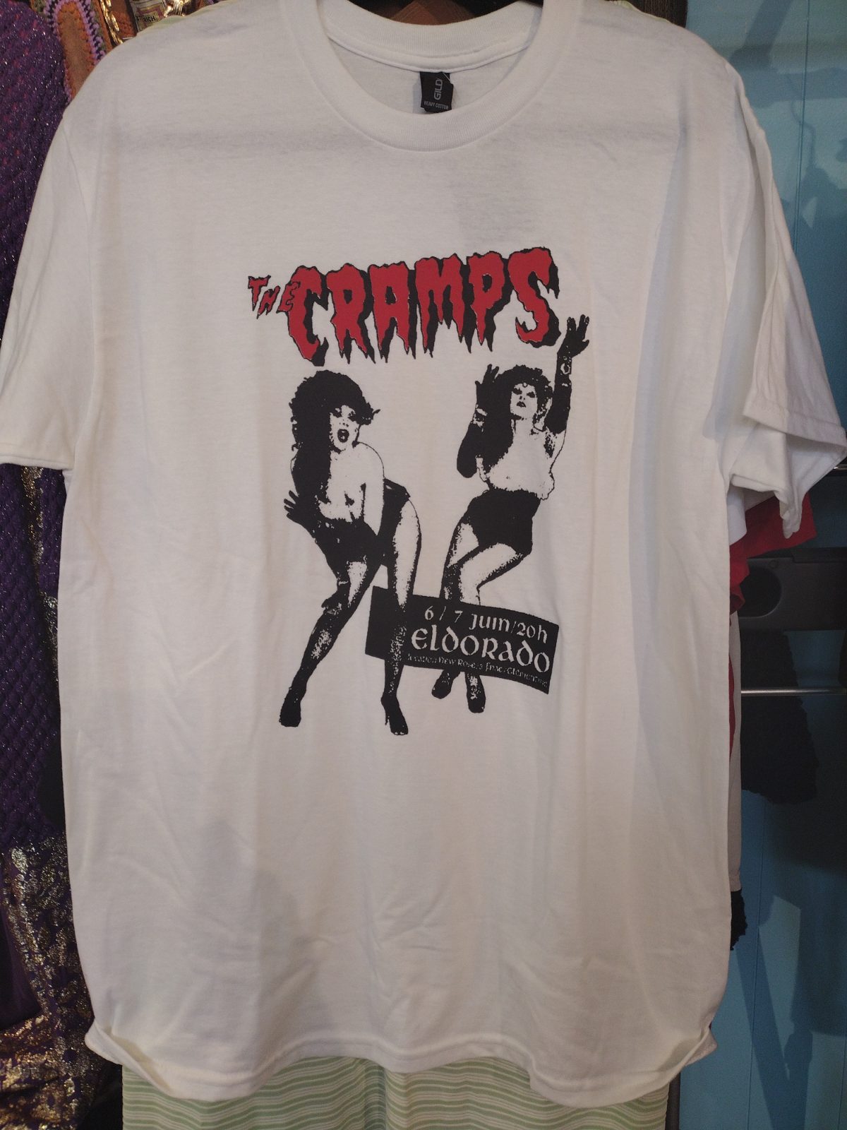 White t-shirt with black and red graphic of the band The Cramps and event details.